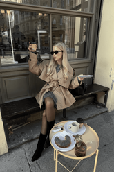 a lady in a grey sweater dress and a trench coat